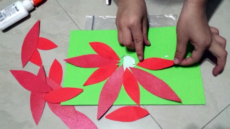 Step 5: Cut a hole in the middle of the front side of the card and then glue the petals around the hole